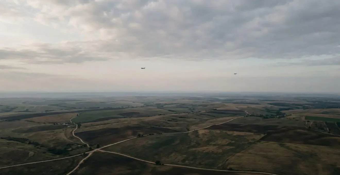 Vue aérienne d'une zone de surveillance étendue avec plusieurs drones en patrouille coordonnée