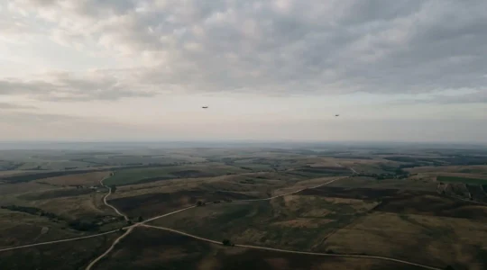 Vue aérienne d'une zone de surveillance étendue avec plusieurs drones en patrouille coordonnée